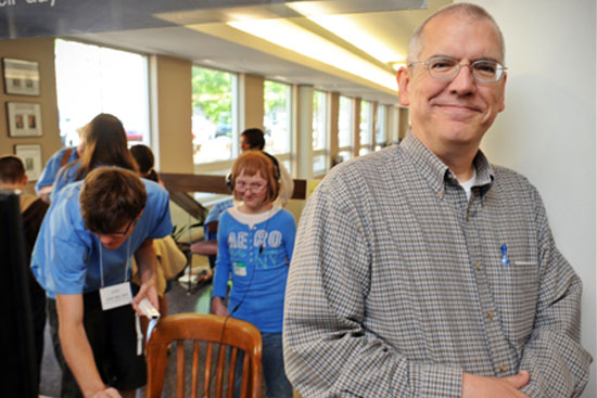 Gary Bishop stands in the foreground while UNC students help children with audio equipment for listening to books