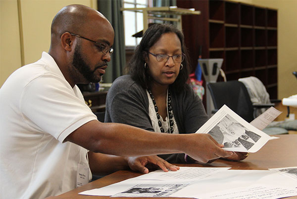 a male and female teacher look at photos from the Civil Rights Movement