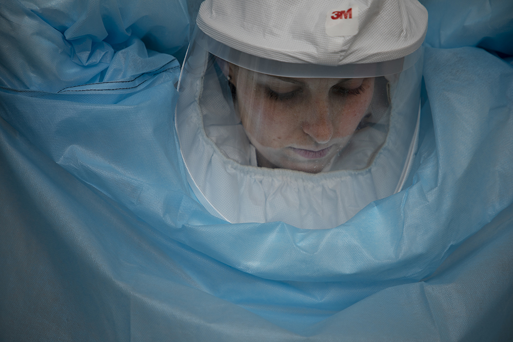 a young woman adjusts her blue BSL3 suit