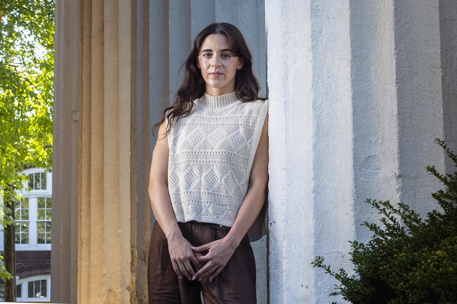 Kaylee O'Brien leaning on a pillar of a courthouse.