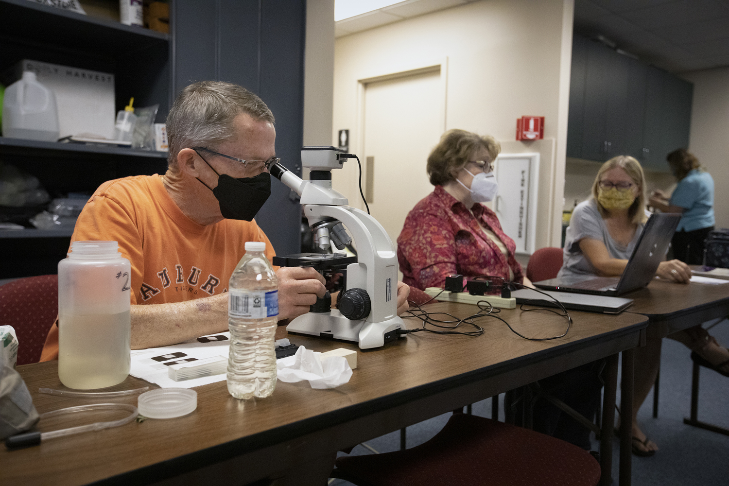 people analyze water samples with microscopes