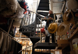 Bobbi Owen stands on scaffolding overlooking a costume storage room
