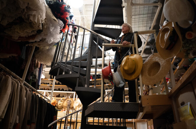 Bobbi Owen stands on scaffolding overlooking a costume storage room