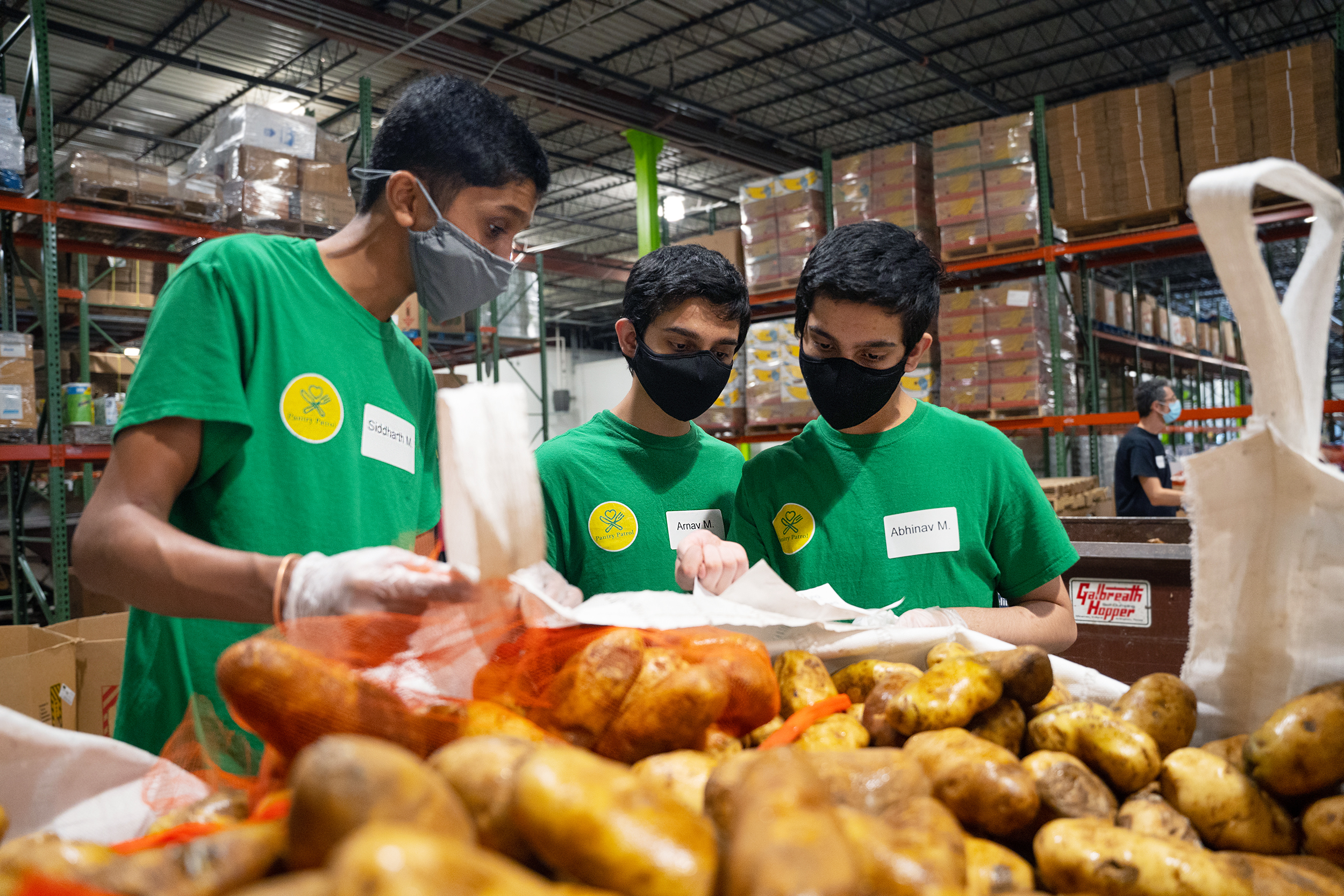 Siddharth Maruvada, Arnav Meduri, and Abhinav Meduri sort through potatoes