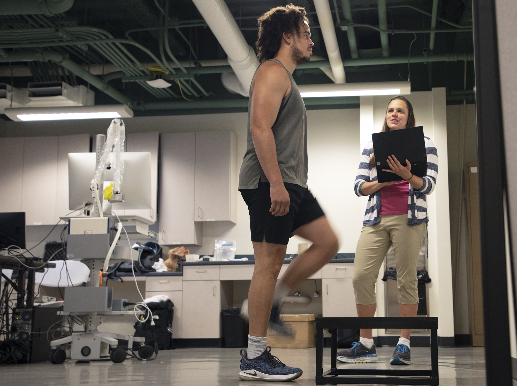 Julianna Prim (right) monitors Ryan Brooks' heart rate on a computer as he steps up on a platform