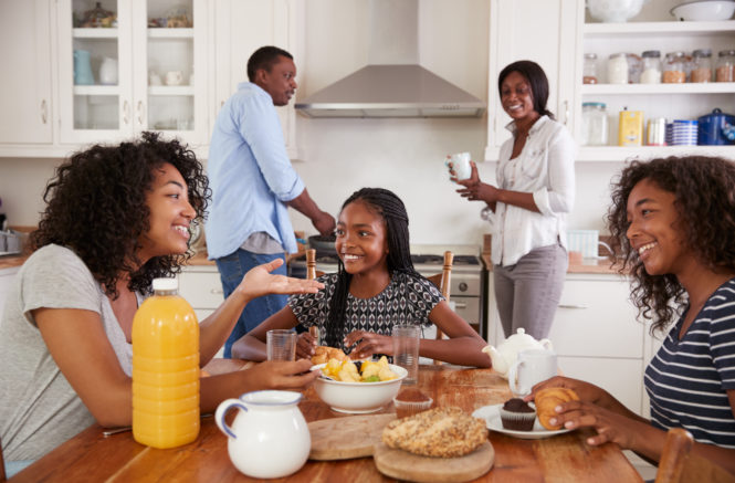 Family With Teenage Children Eating Breakfast In Kitchen