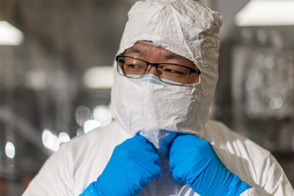 Portrait of Aobo Li as he adjusts his PPE gear.