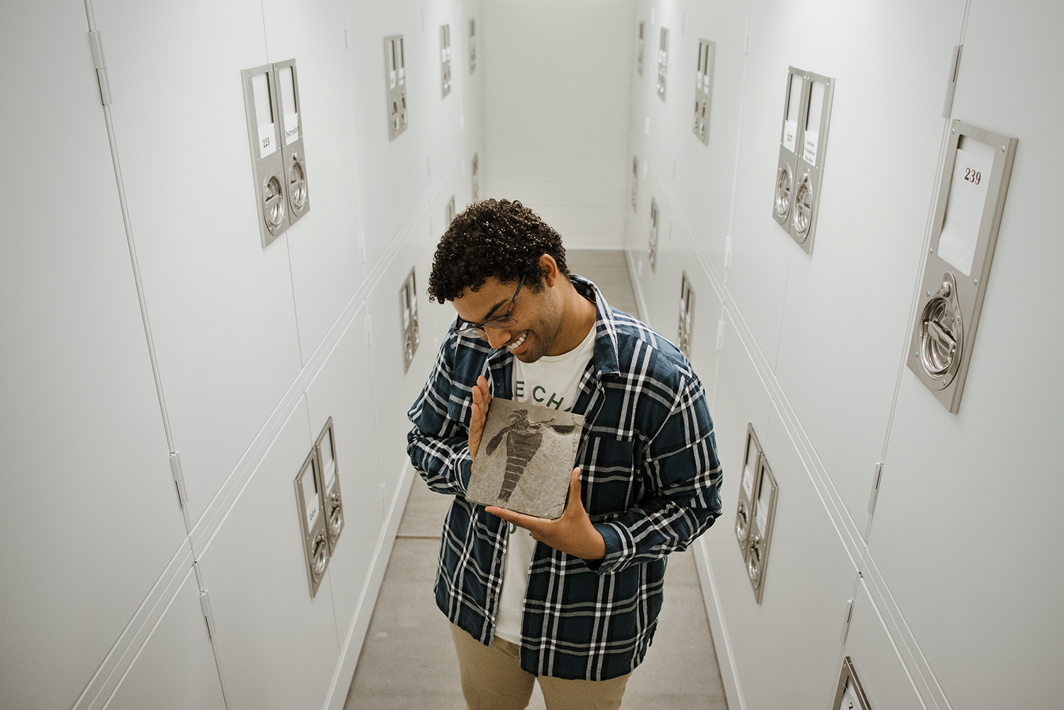 Jared Richards holds a specimen in the paleontology collection at Harvard's Museum of Comparative Zoology