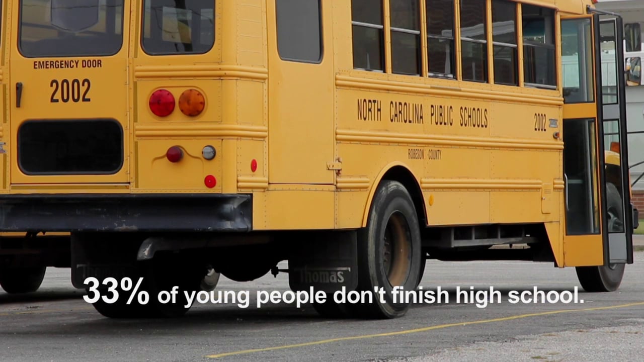 Screen grab of a North Carolina Public Schools bus with the sentence "33% of young people don't finish high school" overlaid onto of it. Click to start video.