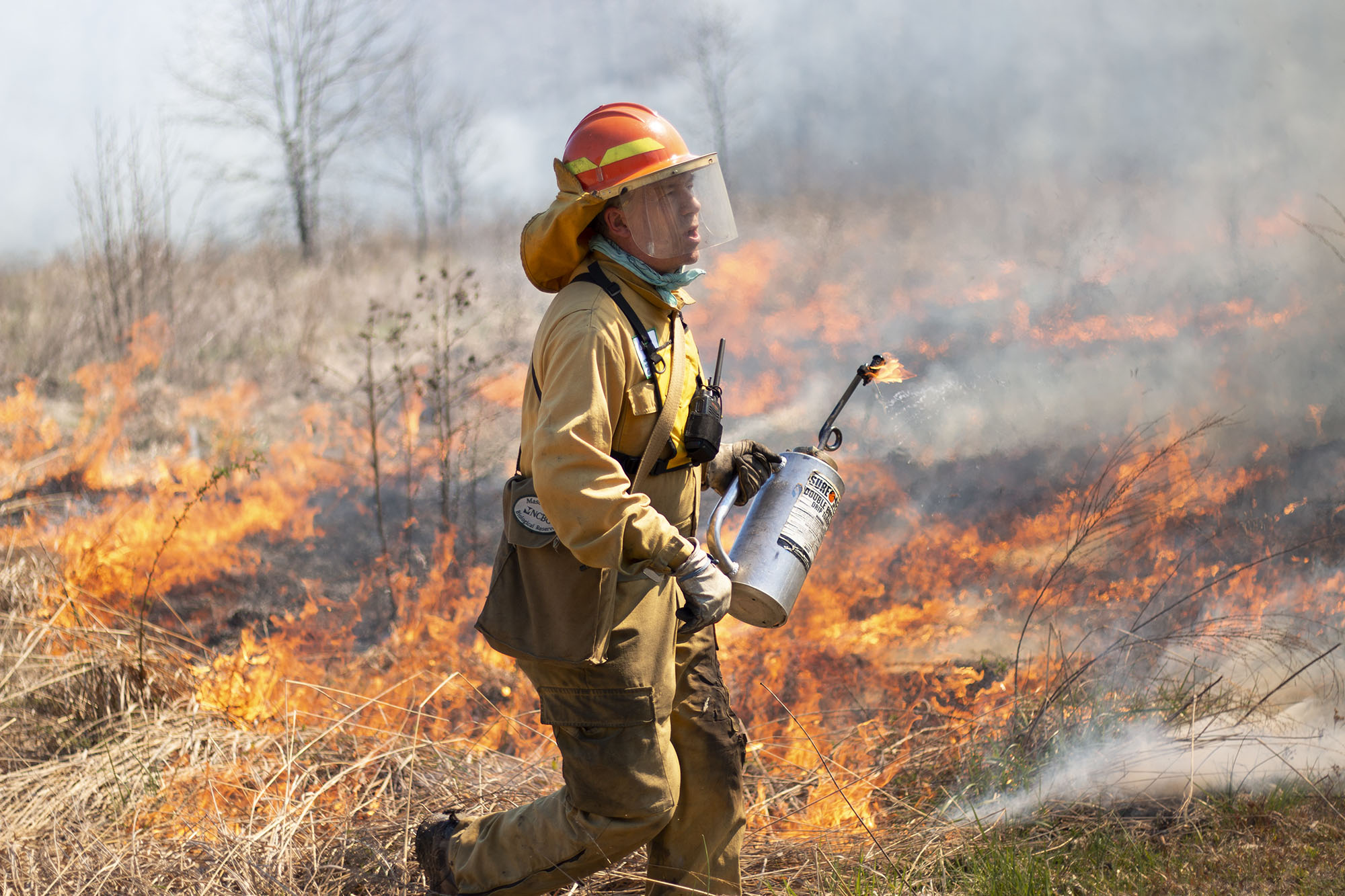 Johnny Randall lights fires during a controlled burn at the Mason Farm Biological Reserve.