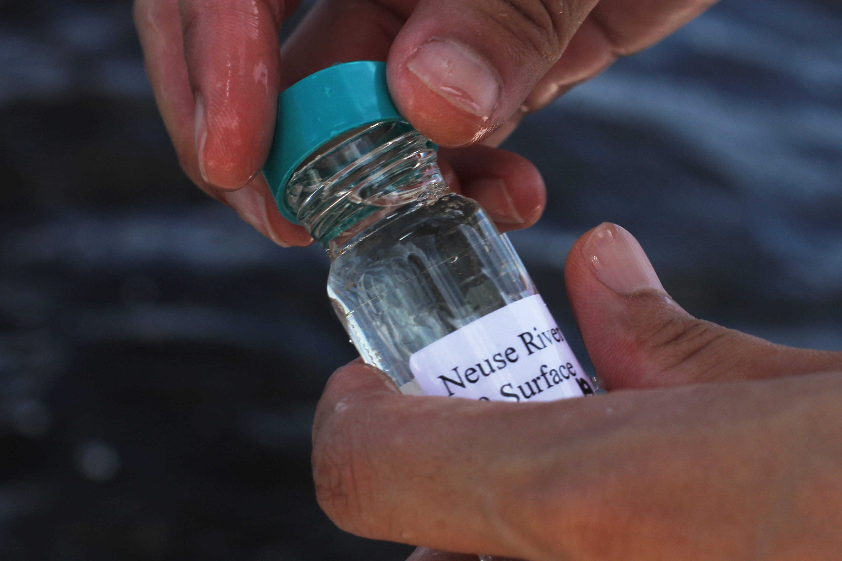 Weida Gong collects a water sample for sequencing from the Neuse River