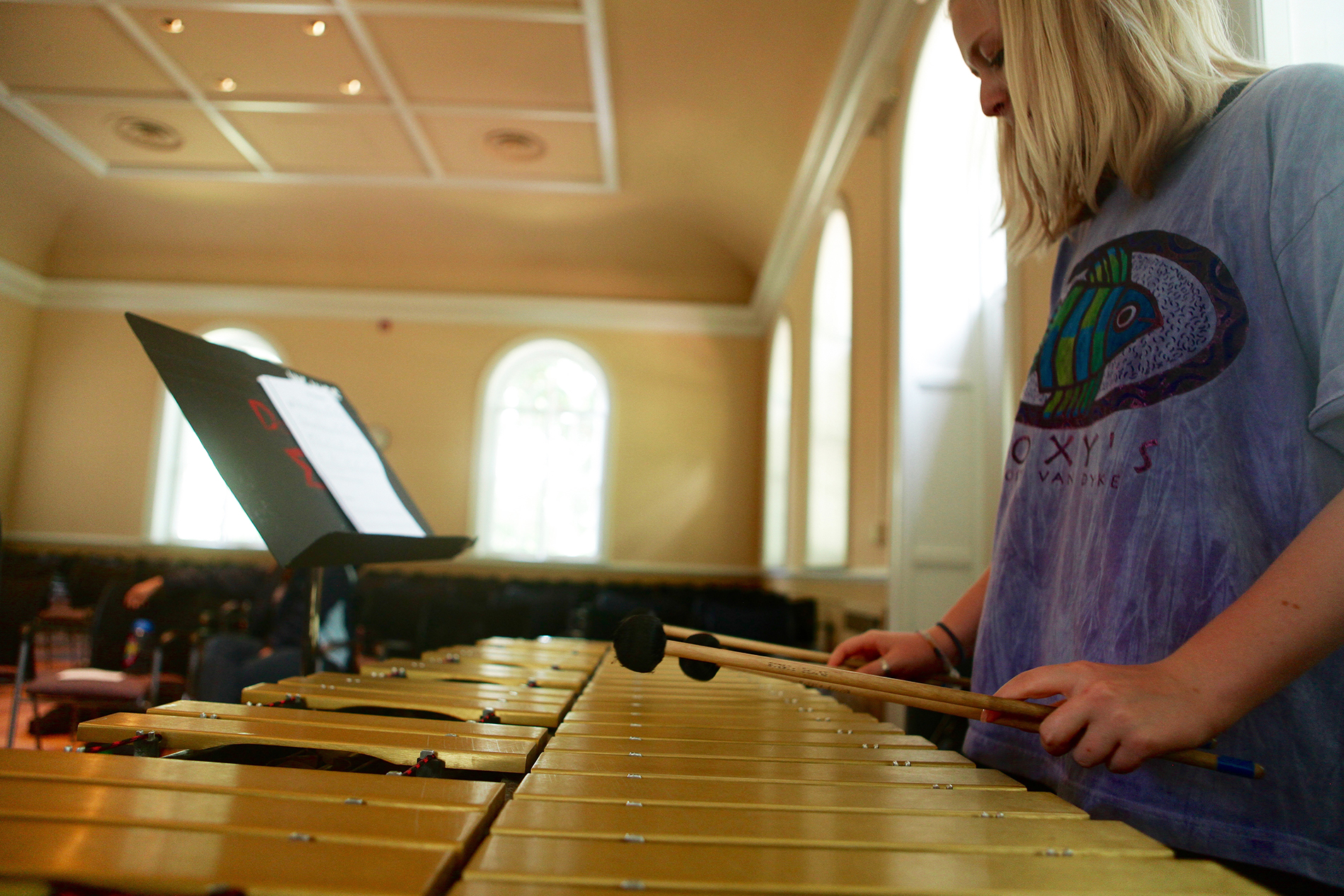 a young girl plays a xylophone