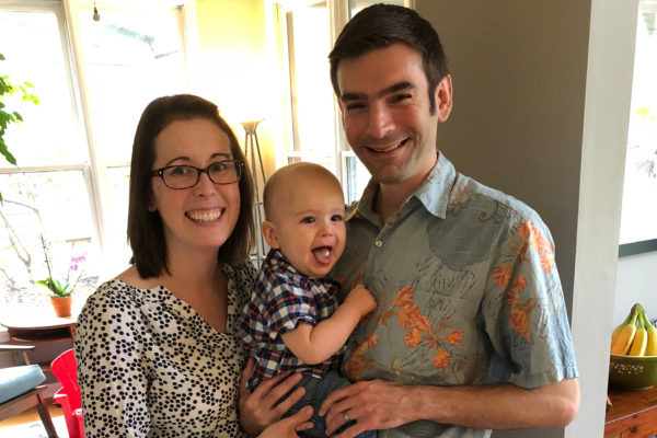 a husband and wife hold their one-year-old son