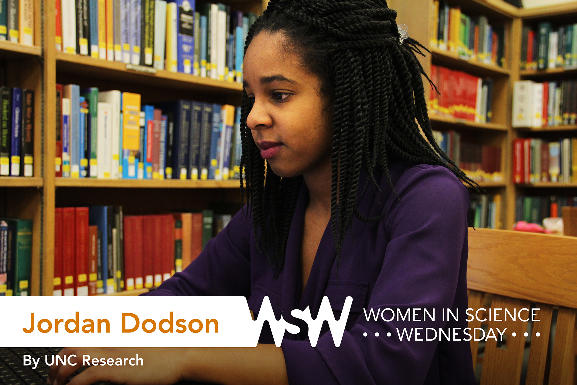 a young African-American woman works on her laptop in a library