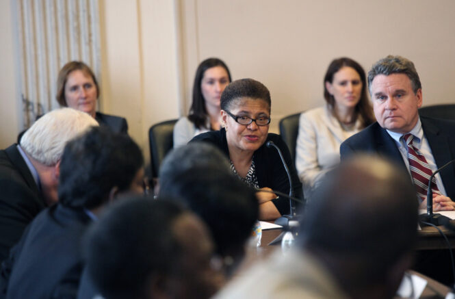 Karen Bass sits at a table surrounded by people
