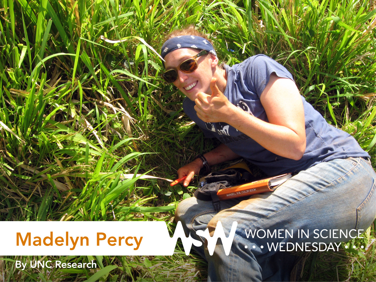 Photo of Madelyn Percy giving a thumbs up as she measures soil drainage on the Galapagos Islands.