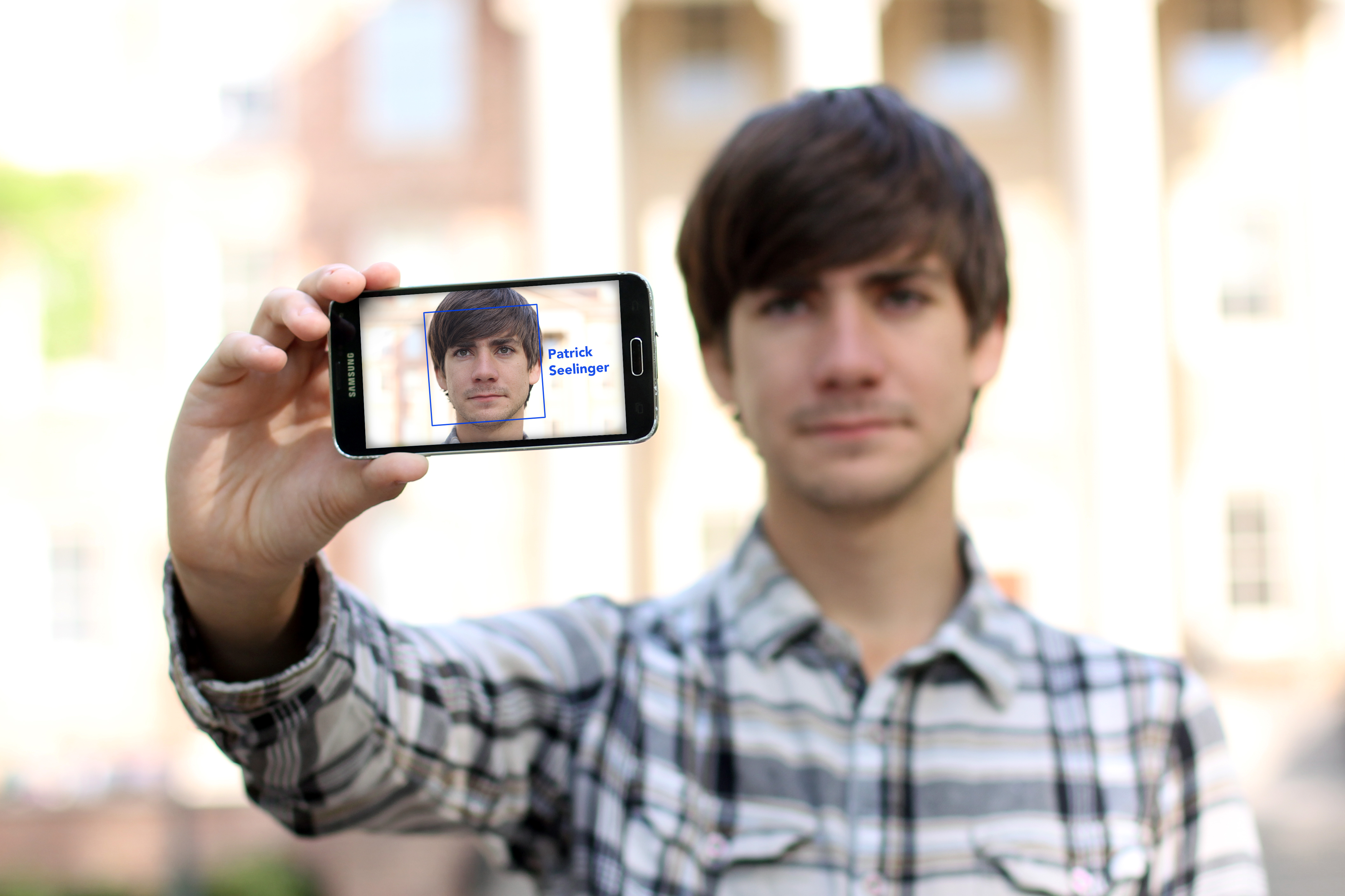 Patrick Seelinger holds up his phone, showing his face to the camera is a blue box around it with the words "Patrick Seelinger" next to it, indicating the it recognizes him