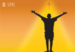 silhouette of someone with their hands outstretched to a glowing cross