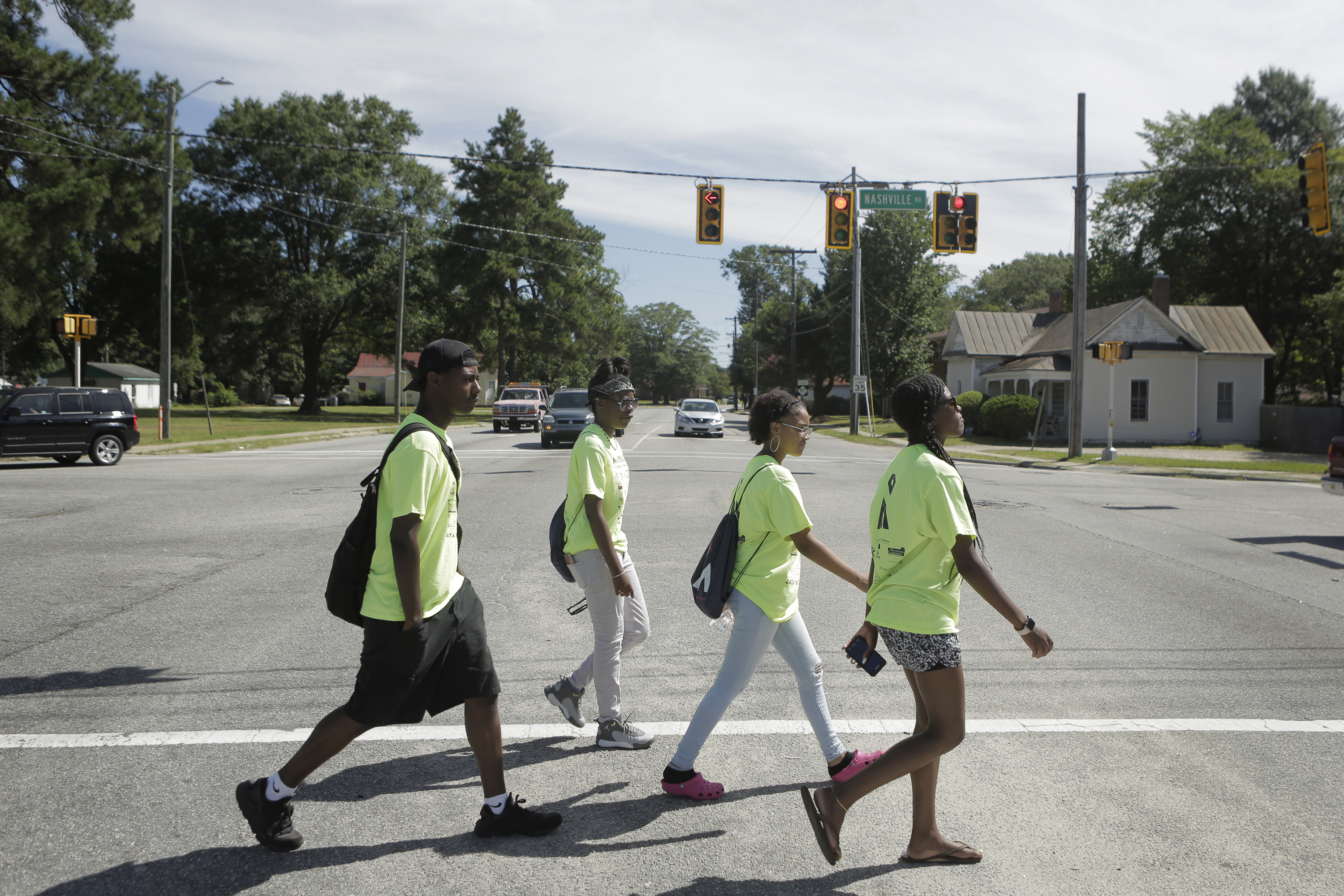 High school students walk through an intersection in Rocky Mount while mapping businesses. Click here to play video.
