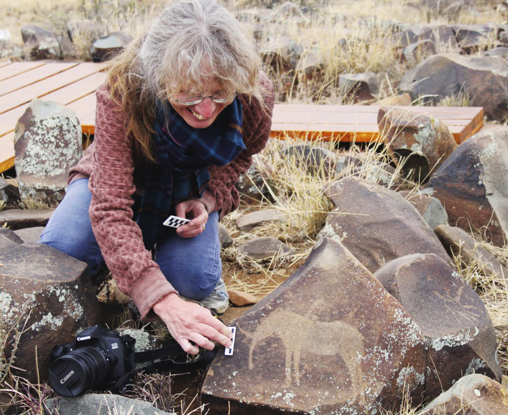 Silvia Tomášková measures an elephant engraving, preparing to take pictures.