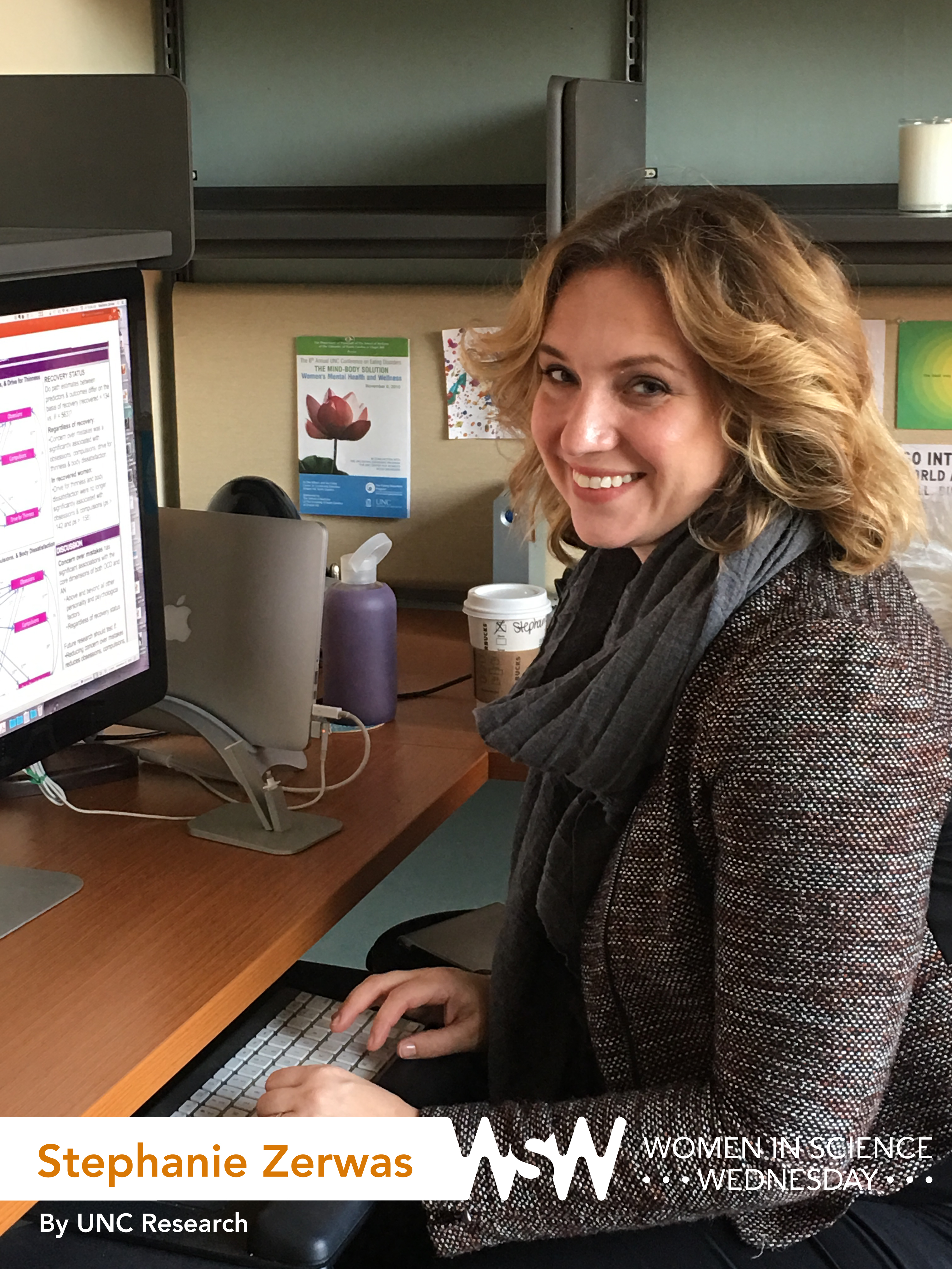 Photo of Stephanie Zerwas posing at her computer with a smile.