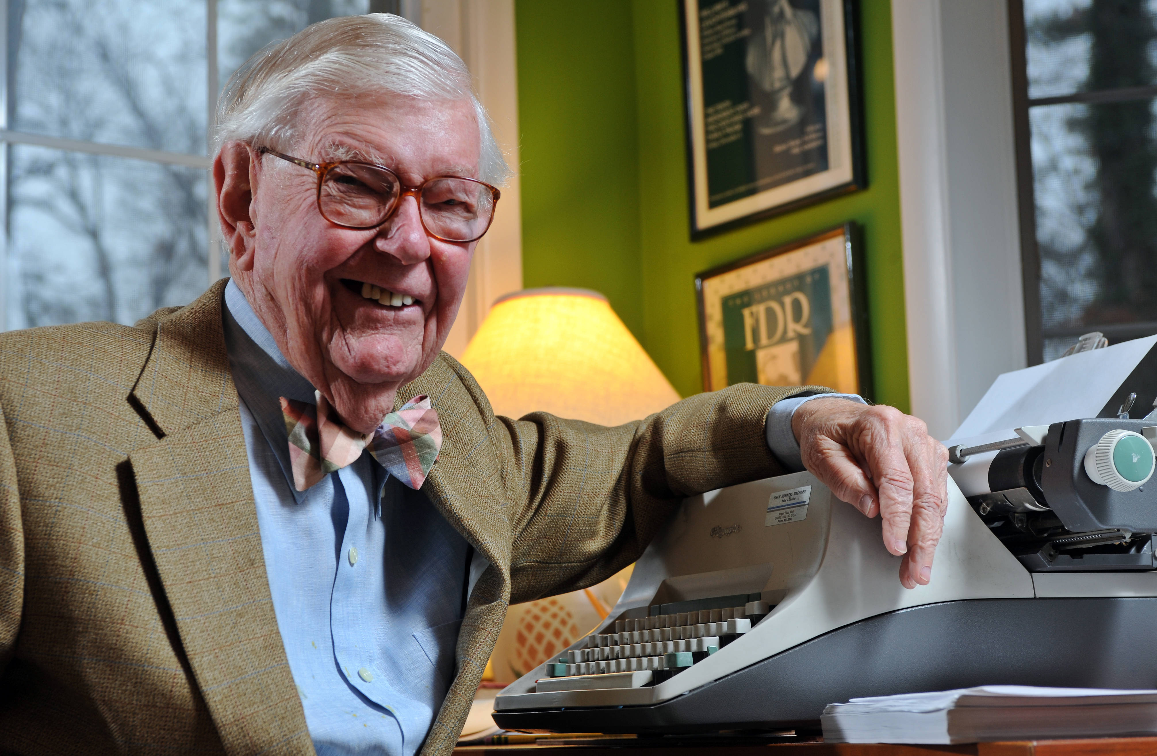 Portrait of William Leuchtenburg in his study, in front of a typewriter.