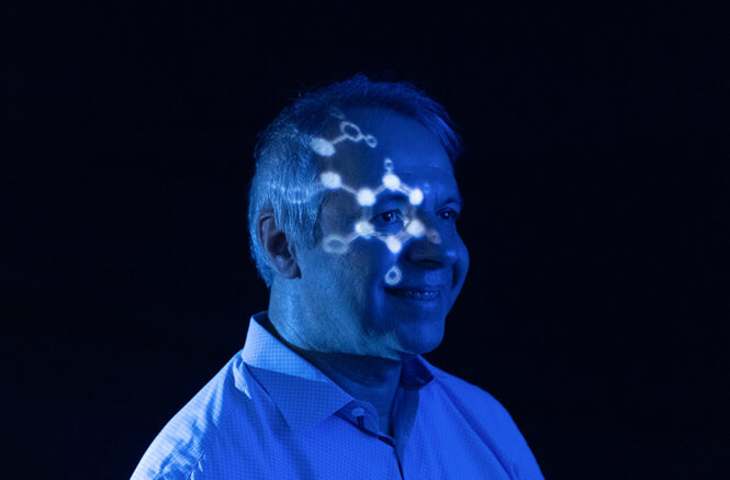 a man with a projection of a molecule on his face