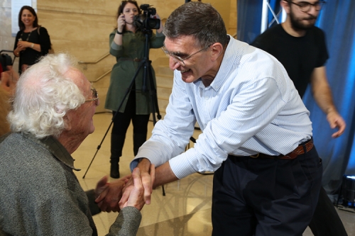 Photo of Oliver Smithies congratulating Aziz Sancar, holding one another's hands.