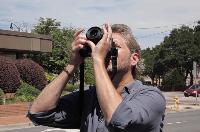 John Bechtold holds a camera and shoots up