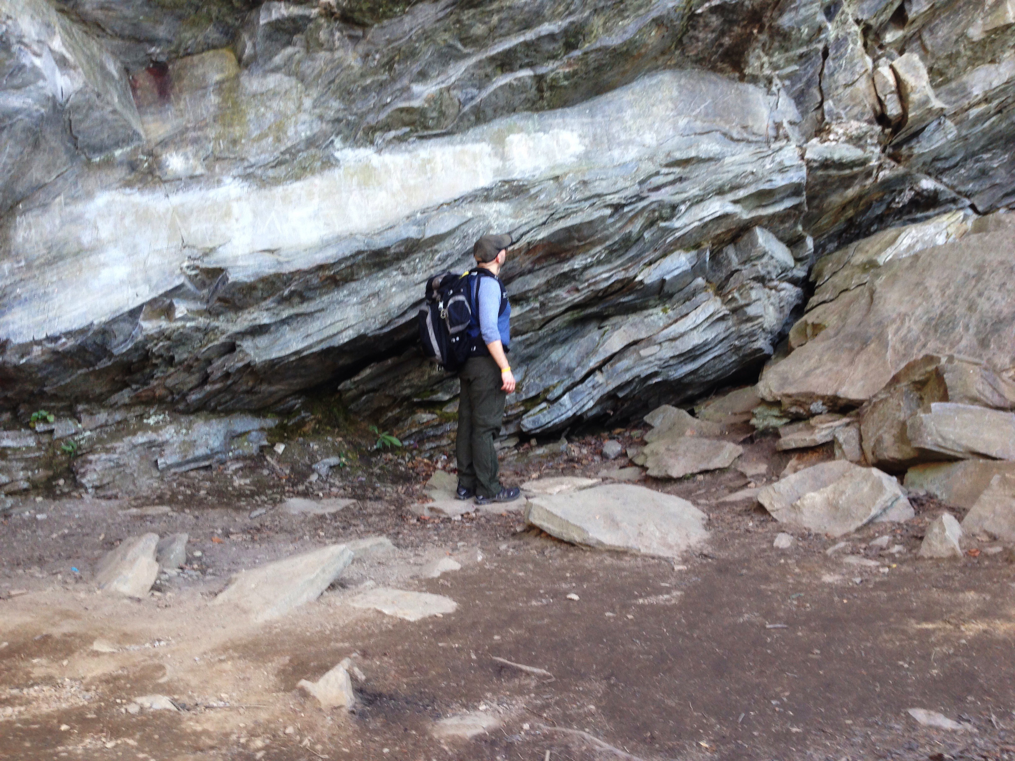 Berk Biryol observes a large, gray rock.