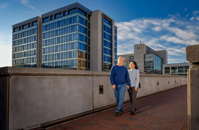 Bill Miller and Clara Lee cross the bridge over Manning Drive on UNC's medical campus