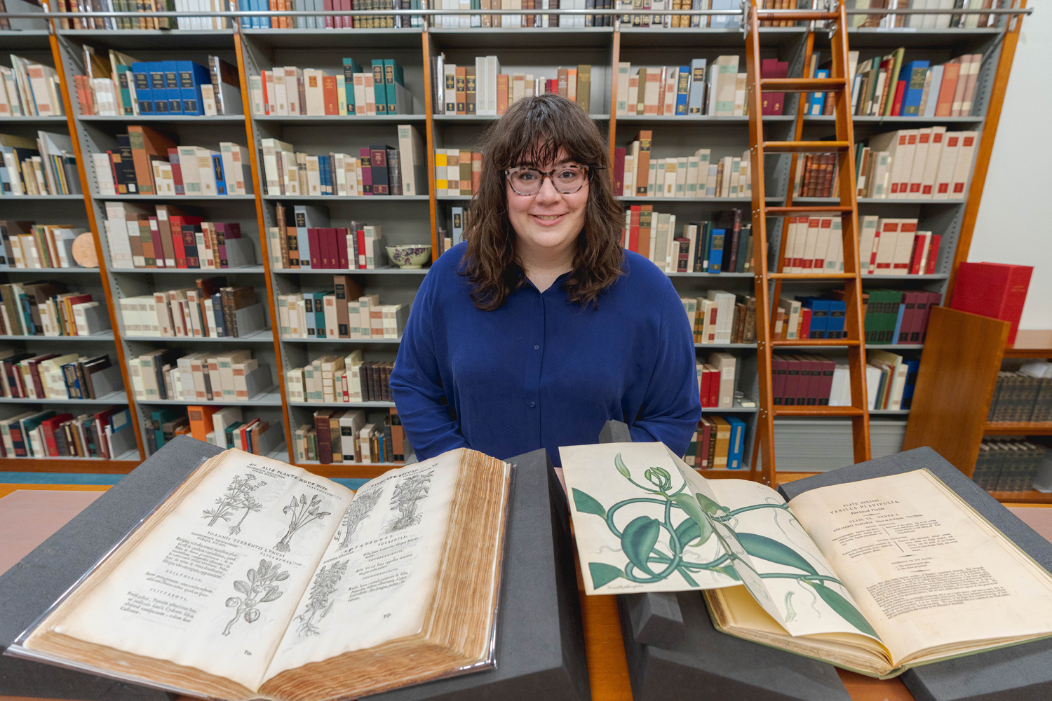 Claire Bunschoten sits with botanical texts at the NY Botanical Garden