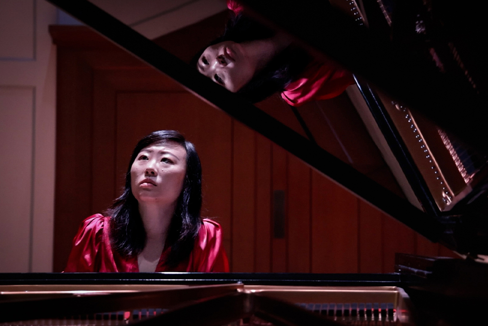 a woman playing a grand piano