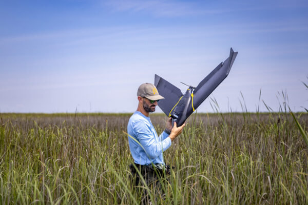 Troy Walton recovers drone from marsh