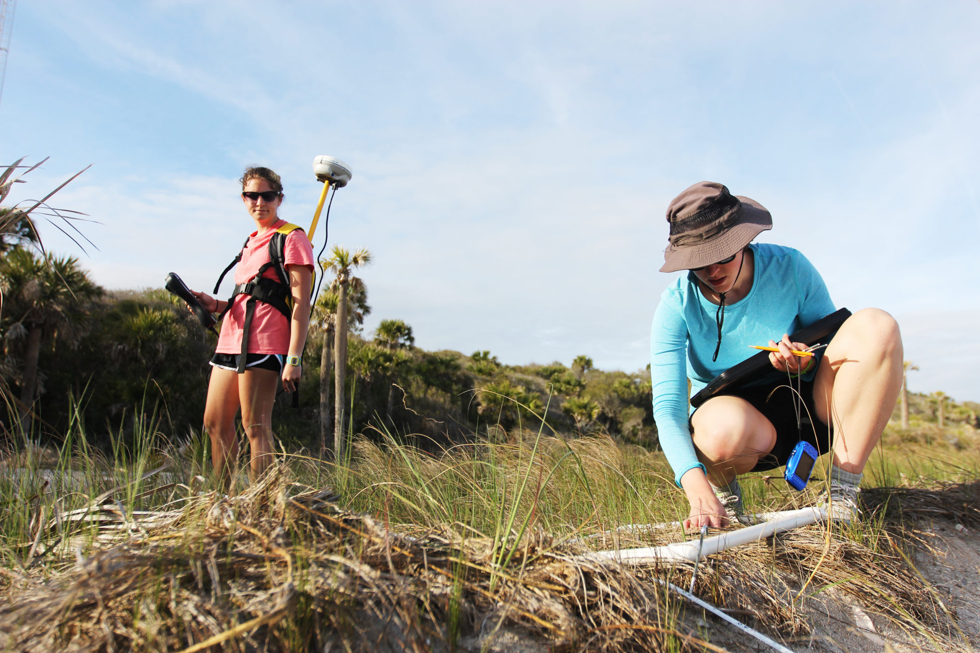 Elsemarie deVries measures the vegetation along her last transect while Atencio gathers the GPS points of each quadrat