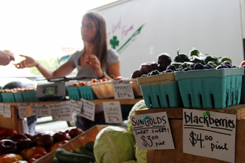 Photo of customers purchasing produce from a vendor at The Durham Farmers' Market.