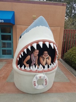 Stephanie Smith and friend pose inside a set of plastic shark jaws