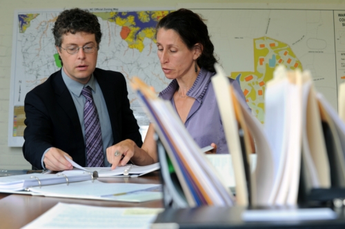 Photo of Gabriel Cummings and Heather Hunt looking of paper and discussing.