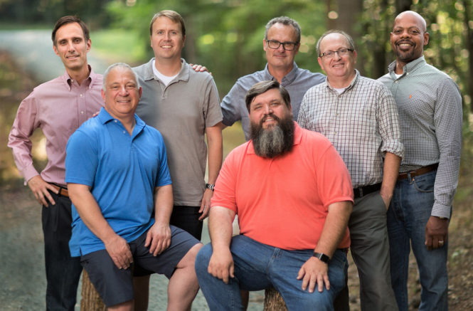 seven men from a widowed fathers support group stand together and pose for a photo