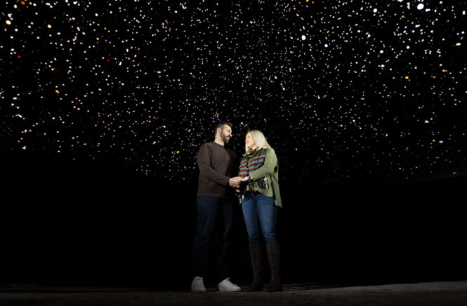 Manuel and Megan Maeso under the starry sky of the full dome theater at Morehead Planetarium