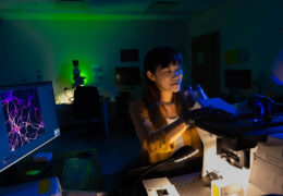 Michelle Itano looks at microscope slides in the UNC Neuroscience Microscopy Core