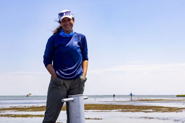 a young woman stands in the ocean at low tide