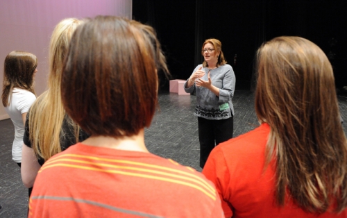 Photo of Heather Patterson King talking to students during a PlayMakers outreach program.