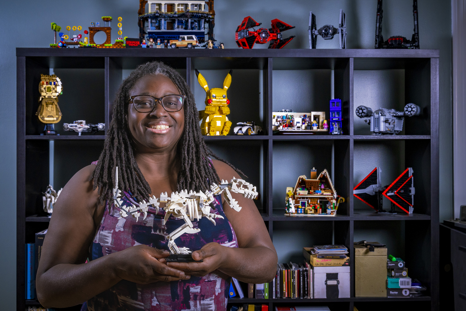 Priscilla Layne holds a complete LEGO T-rex