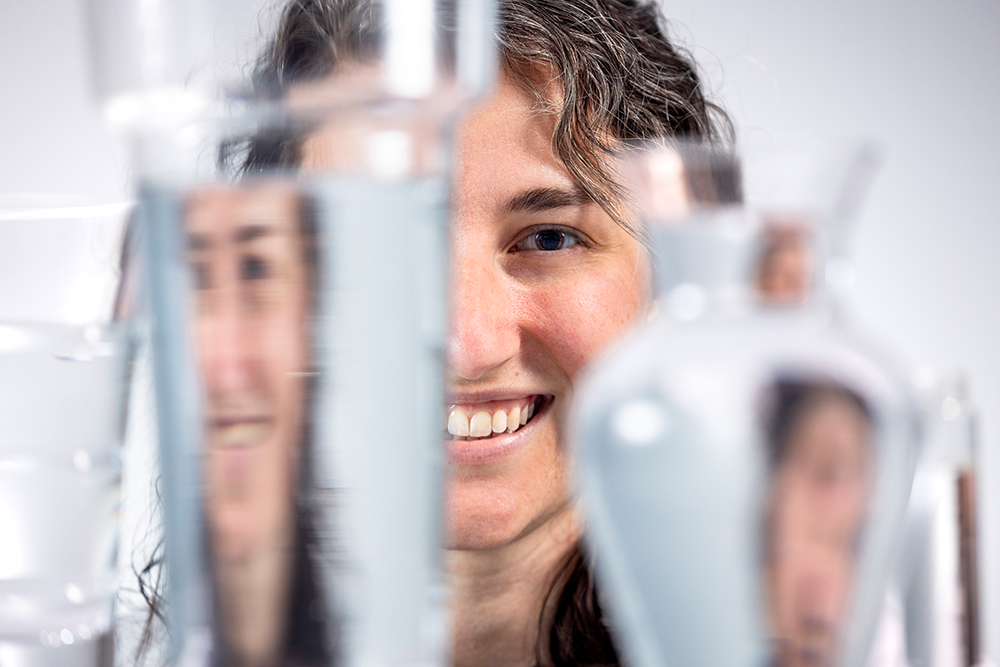 Taylor Teitsworth looks through various containers filled with water