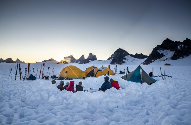 four tents set up in a snowfield in Alaska