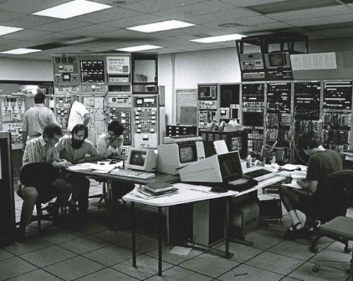 Old photo of professors Tom Clegg and Hugon Karwowski in the lab with their students during the 1980s, conducting a tandem accelerator experiment.