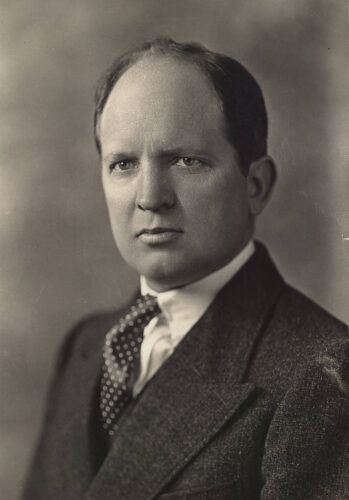 Photo: A black-and-white portrait of a man wearing a suit and a polka-dotted tie.